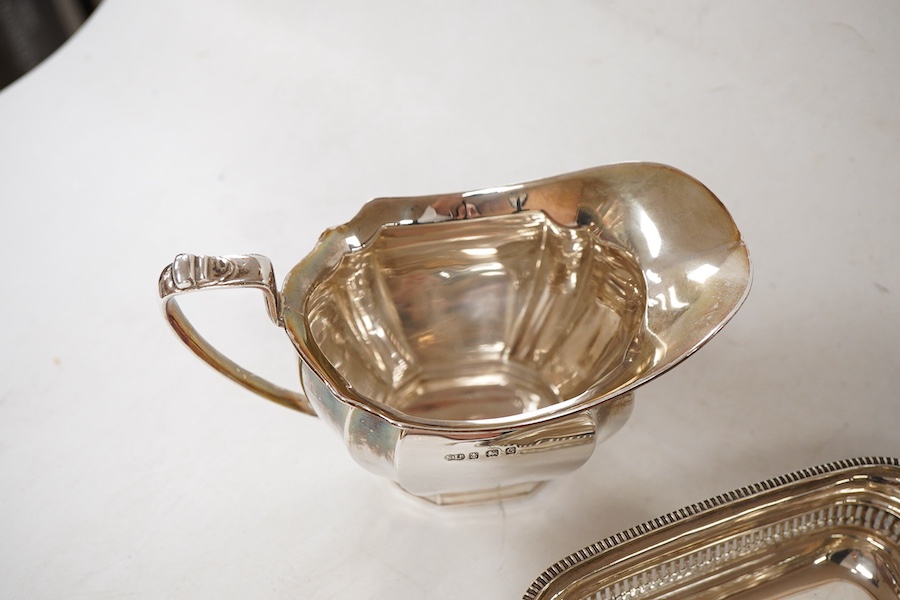 A George V silver two handled butter dish, by George Howson, Sheffield, 1928, 16.7cm over handles, together with a George V silver cream jug, by William Suckling Ltd, Birmingham, 1931, 10.7oz.